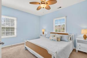 a bedroom with blue walls and a bed with a ceiling fan at 2BR Condo with Golf Views Near Sunset Beach in Sunset Beach +61 photos