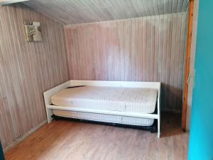 a small bedroom with a white bed in a room at chalet dans les pins in Carcans +3 photos