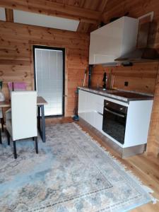 a kitchen with a stove and a table in a room at Holzhaus Riegersburg in Riegersburg +2 photos