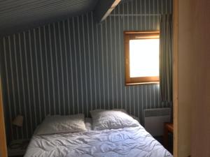a bedroom with a bed and a window at chalet dans les pins in Carcans