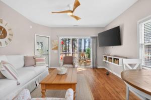 a living room with a white couch and a table at 2BR Condo with Golf Views Near Sunset Beach in Sunset Beach
