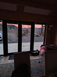 a room with three windows with a view of a lake at Holzhaus Riegersburg in Riegersburg
