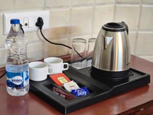 a tea kettle and a bottle of water on a counter at Kavin Uphar The Mall Road in Shimla