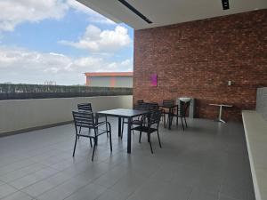 a patio with tables and chairs and a brick wall at Aliffheight in Johor Bahru