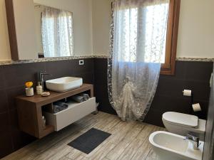 a bathroom with a sink and a toilet and a mirror at B&B Il Sentiero in Noale