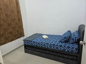 a small bed with a blue comforter and pillows at Aliffheight in Johor Bahru +2 photos