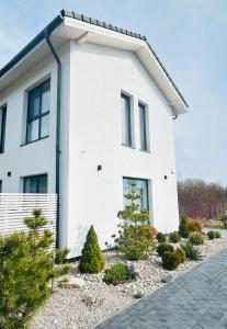 a white house with plants in front of it at Rami Jūra 2022 in Šventoji