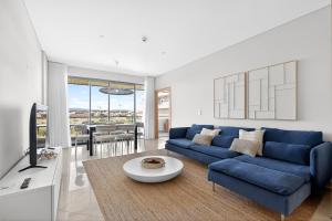 a living room with a blue couch and a table at Aquamar Pro 402 in Quarteira