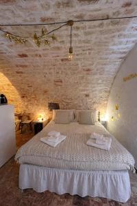 a bedroom with a bed with two towels on it at Soffio di Pietra in Castellana Grotte