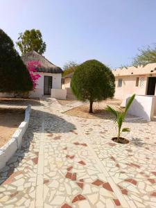a stone walkway in front of a house at A La Teranga in Poundiougne +18 photos