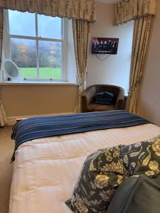 a bedroom with a bed and a window and a chair at Springfield House in Grasmere +26 photos
