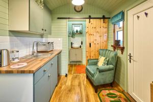 a kitchen with a green chair and a sink at Host & Stay - Curlews Rest in Longridge