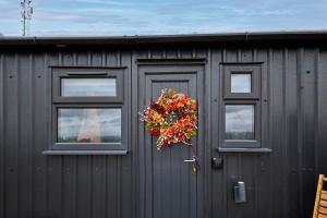 a building with three windows and a wreath on it at Host & Stay - Curlews Rest in Longridge