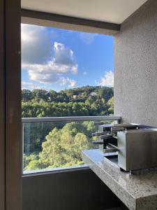 a window in a bathroom with a view of a forest at Refugio do Sol in Extrema