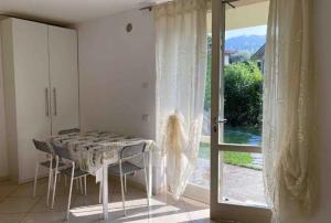 a dining room with a table and a glass door at Poggio ai Vigneti in Entratico