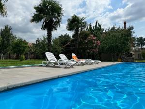 a group of chairs sitting next to a swimming pool at Aisi Villa in Misakʼtsʼieli