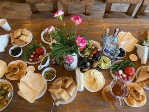 a wooden table topped with lots of plates of food at Aisi Villa in Misakʼtsʼieli