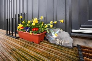 a pot of flowers sitting next to a sign at Host & Stay - Swallows Nest in Longridge