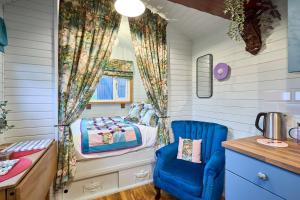 a small bedroom with a bed and a blue chair at Host & Stay - Swallows Nest in Longridge
