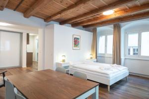 a bedroom with a bed and a table and chairs at HITrental Eisengasse Apartments in Lucerne