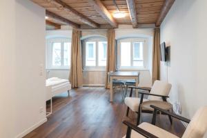 a living room with a table and chairs and windows at HITrental Eisengasse Apartments in Lucerne