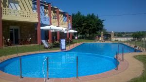 a large blue swimming pool in front of a building at Ydna Apartments in Possidi