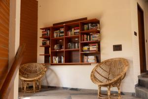 two wicker chairs sitting next to a book shelf at DrUnni's Ayurveda Resort in Kovalam