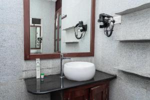 a bathroom with a sink and a mirror at DrUnni's Ayurveda Resort in Kovalam