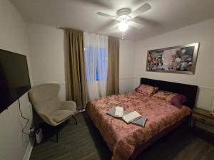 a bedroom with a bed and a chair and a fan at Brossard home in Brossard