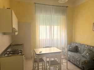 a kitchen and living room with a couch and a table at Smart Convenient Apartments Orosei in Orosei +1 photo