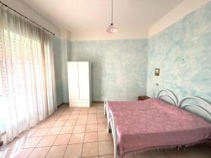 a bedroom with a pink bed and a window at Smart Convenient Apartments Orosei in Orosei