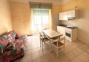 a living room with a table and a kitchen at Smart Convenient Apartments Orosei in Orosei