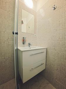 a bathroom with a sink and a mirror at Studio Ariel in Veľký Meder +16 photos