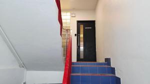a stairway with blue and red stairs and a black door at SUP Hometel Phuket in Ban Thalat Choeng Thale +60 photos