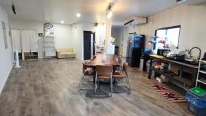 a living room with a table and chairs in it at SUP Hometel Phuket in Ban Thalat Choeng Thale