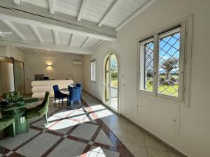 a living room with a table and chairs and windows at Santa Caterina 1604 Suites in Anzola dell'Emilia