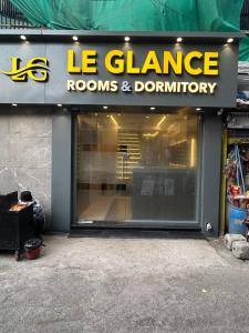 a store front with a le garage rooms and donut shop at Hotel Le Glance Rooms & Dormitory in Mumbai