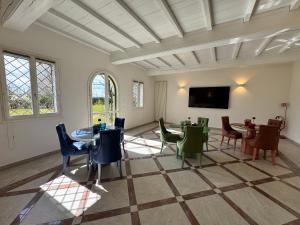 a room with tables and chairs and a flat screen tv at Santa Caterina 1604 Suites in Anzola dell'Emilia
