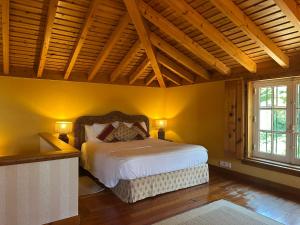 a bedroom with a large bed in a room with yellow walls at Villa Malveira in Alcabideche +66 photos