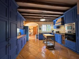 a kitchen with blue cabinets and a table in it at Villa Malveira in Alcabideche