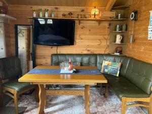 a living room with a table and a couch and a tv at Charmantes Ferienhäuschen in Beetz - in 5 Minuten am See und im Wald in Kremmen