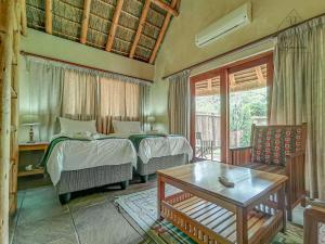 a bedroom with two beds and a table at Cherry Creek at Zebula in Warmbaths