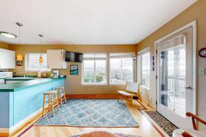 a kitchen with a blue counter and some windows at Oceanfront Nye Beach condo with gorgeous corner view & beach access in Newport