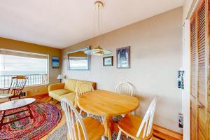 a living room with a table and chairs and a couch at Oceanfront Nye Beach condo with gorgeous corner view & beach access in Newport +6 photos