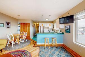 a kitchen and living room with a table and chairs at Oceanfront Nye Beach condo with gorgeous corner view & beach access in Newport