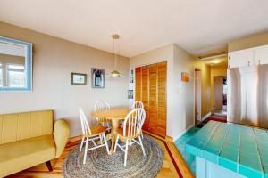 a living room with a table and chairs and a couch at Oceanfront Nye Beach condo with gorgeous corner view & beach access in Newport