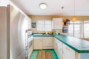 a kitchen with white cabinets and green tile floors at Oceanfront Nye Beach condo with gorgeous corner view & beach access in Newport
