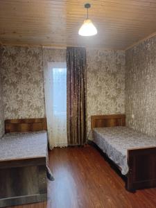 a bedroom with two beds and a window and a light at Gugas cottage and guest house in Lakhiri in Lakhiri