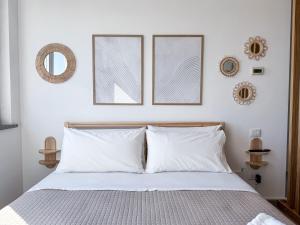 ein Schlafzimmer mit einem Bett und drei Bildern an der Wand in der Unterkunft Fly & Chill Ciampino Airport in Ciampino