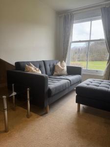 a living room with a blue couch and a window at Springfield House in Grasmere